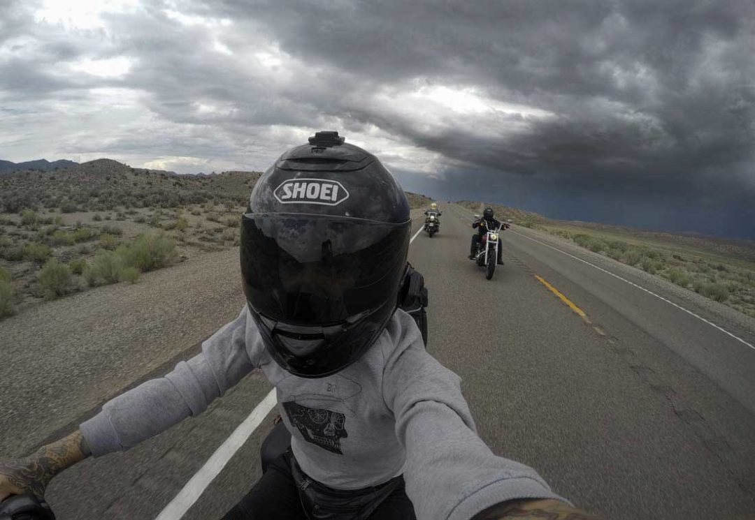 Motorcycle riders surrounded by a dark, stormy sky