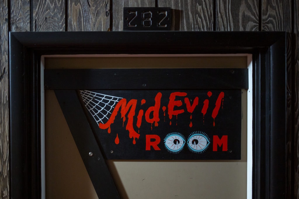 The Mid-Evil room sign has a spiderweb and bloody type
