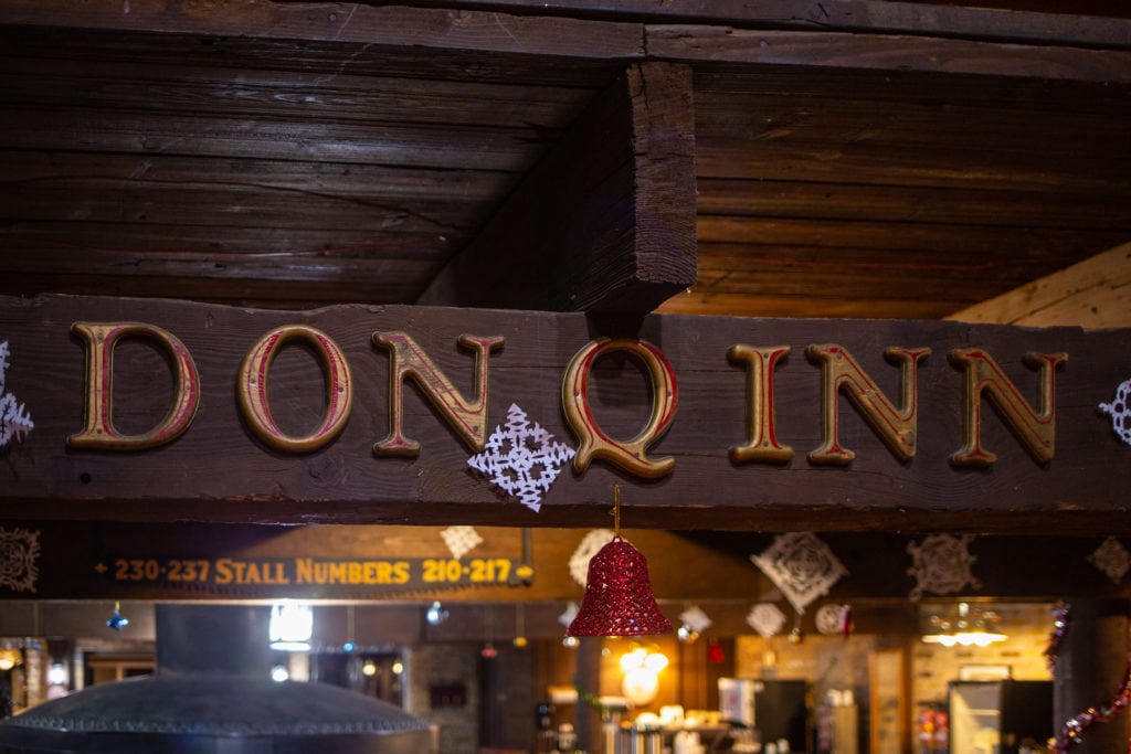 The lobby features a wooden sign that spells out Don Q Inn