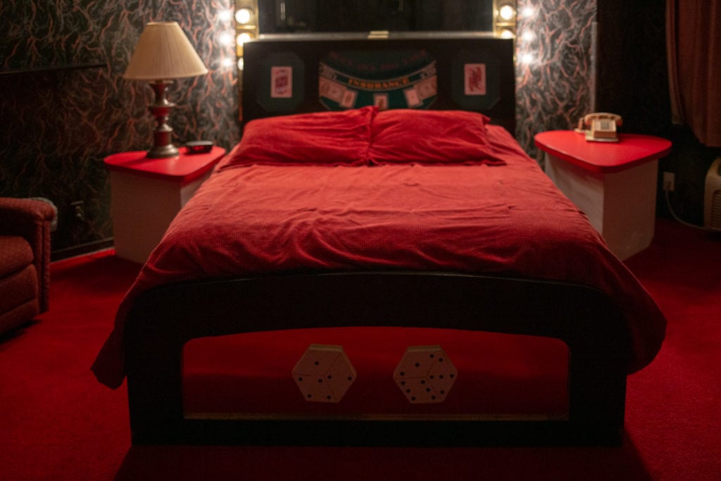 The casino royale suite has a red bed with a headboard modeled from a poker table