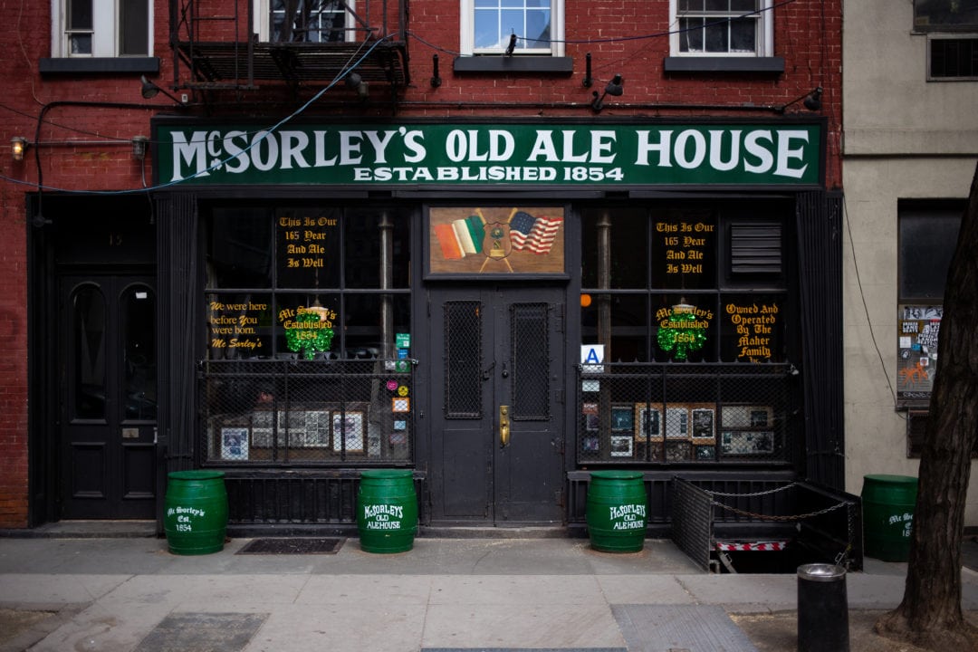 The outside of McSorley's has a green sign and shamrocks