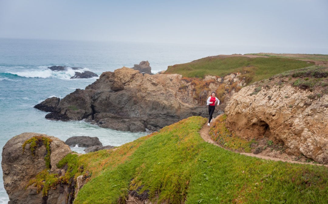 A woman running on a trail in Fort Bragg, California
