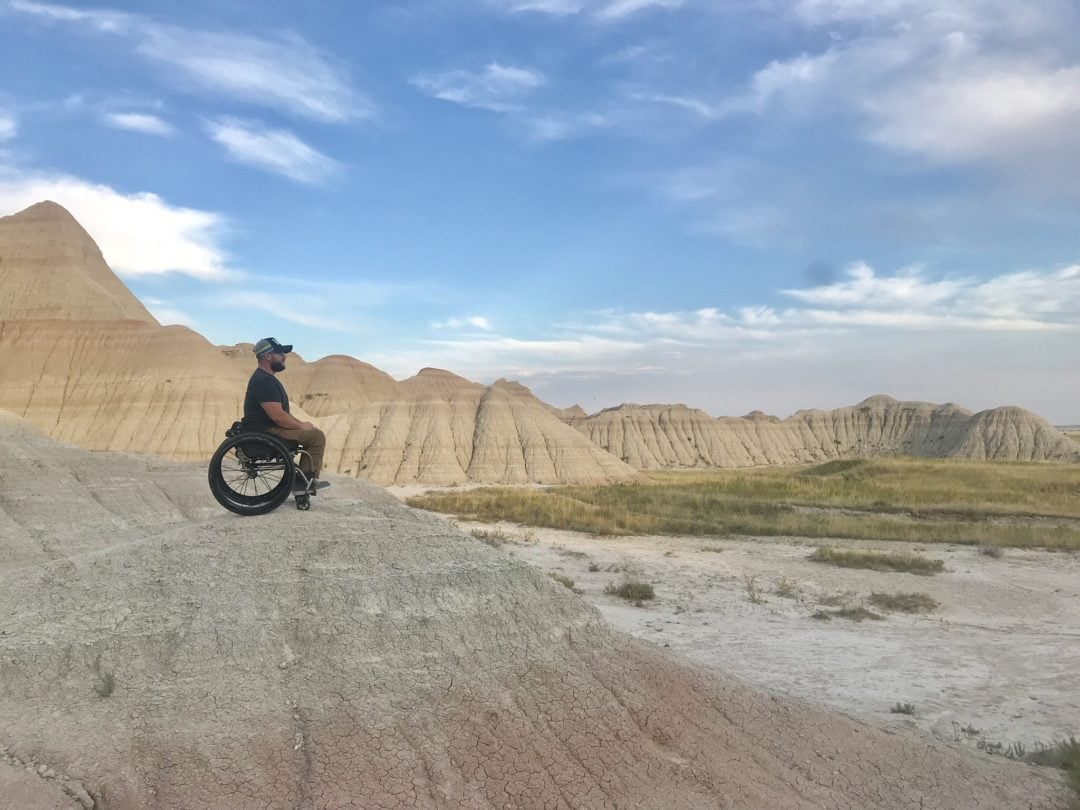 A man in a wheelchair looks out on Badlands National Park