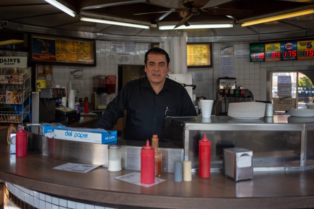 Mario Costa stands behind the counter