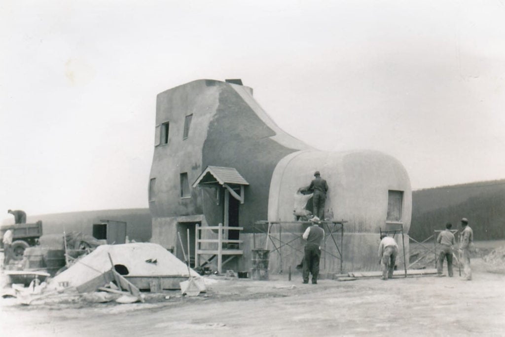A black and white photo of the shoe house under construction
