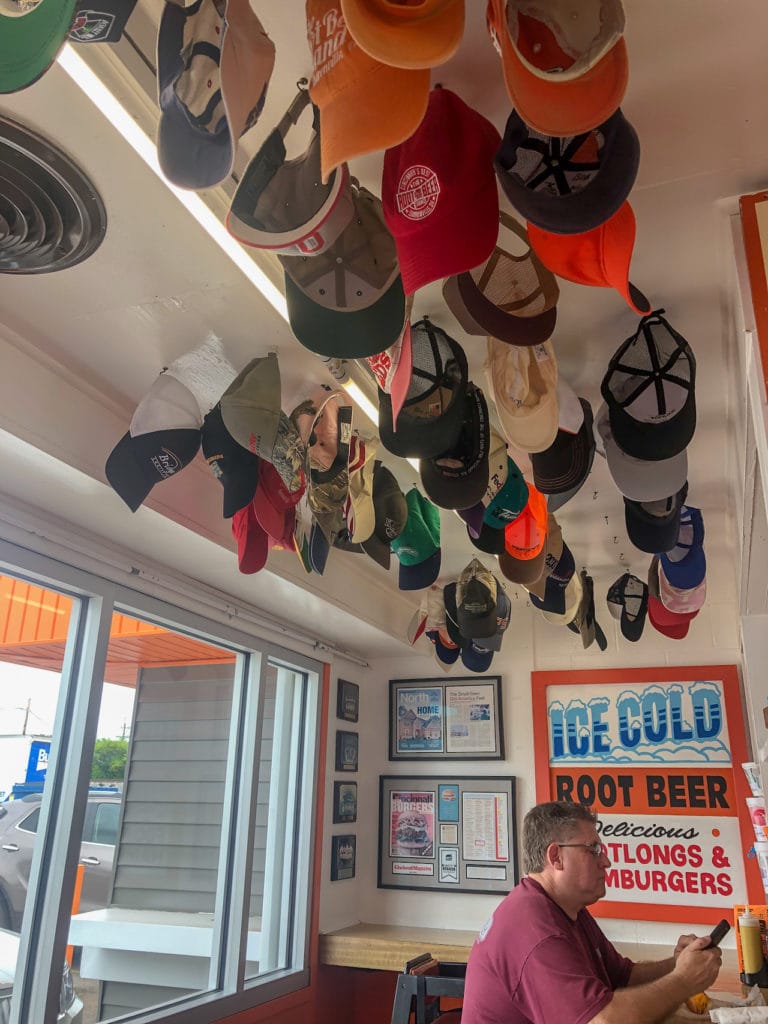 Dozens of hats hang from the ceiling in The Root Beer Stand.