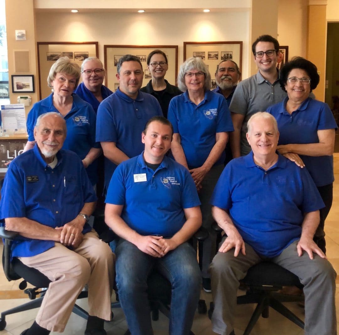 11 individuals in matching blue polos pose for a photograph