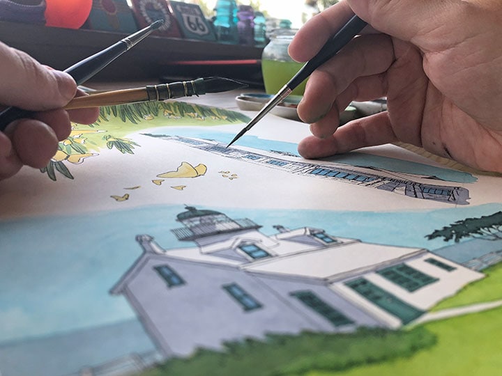 Chandler O'Leary paints a picture of a lighthouse.