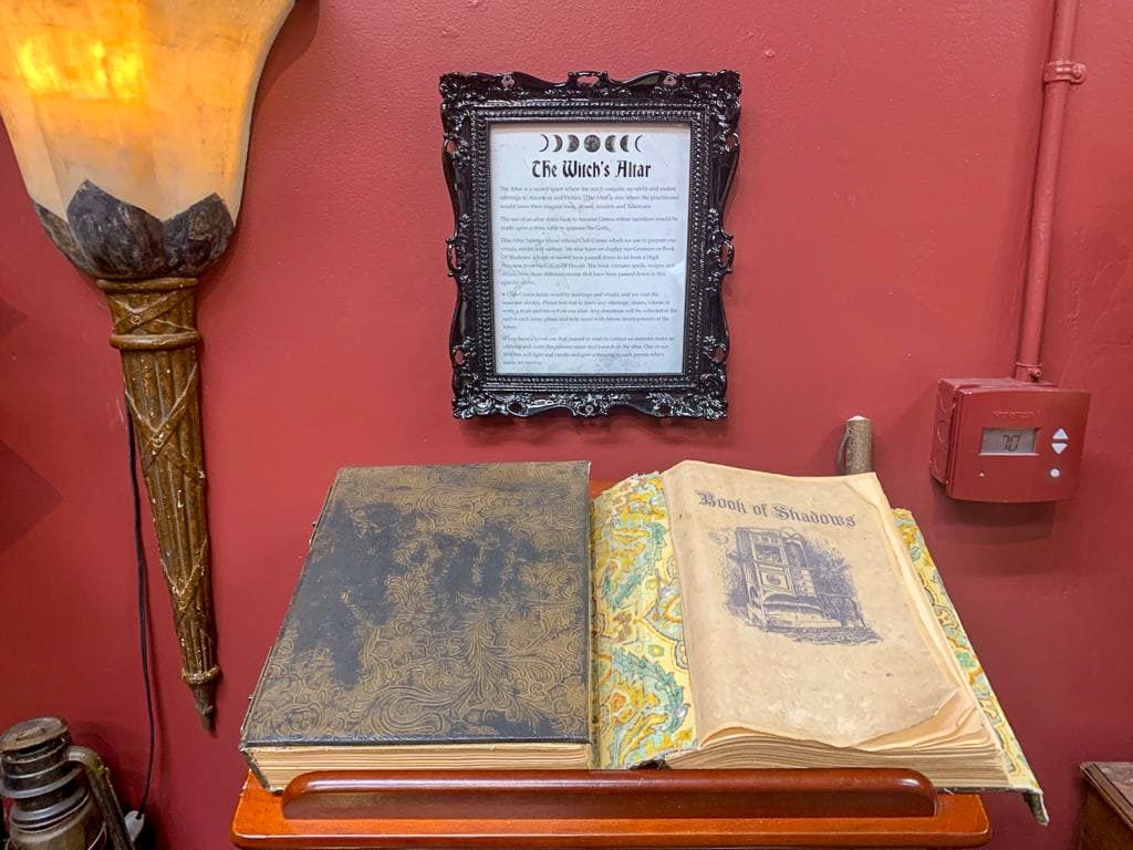 A Book of Shadows sits open in front of The Witch's Altar rules.