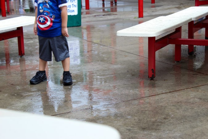 Luckily, the rain didn't last long. Kids, feet, rain, marvel shirt amusement park