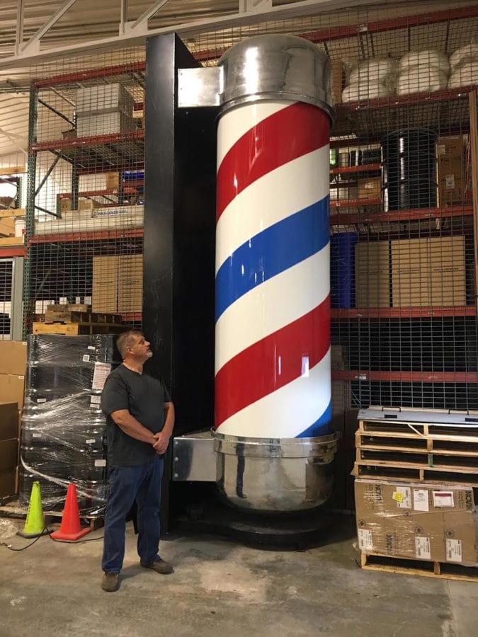 Jim Bolin stands next to a giant barber's pole