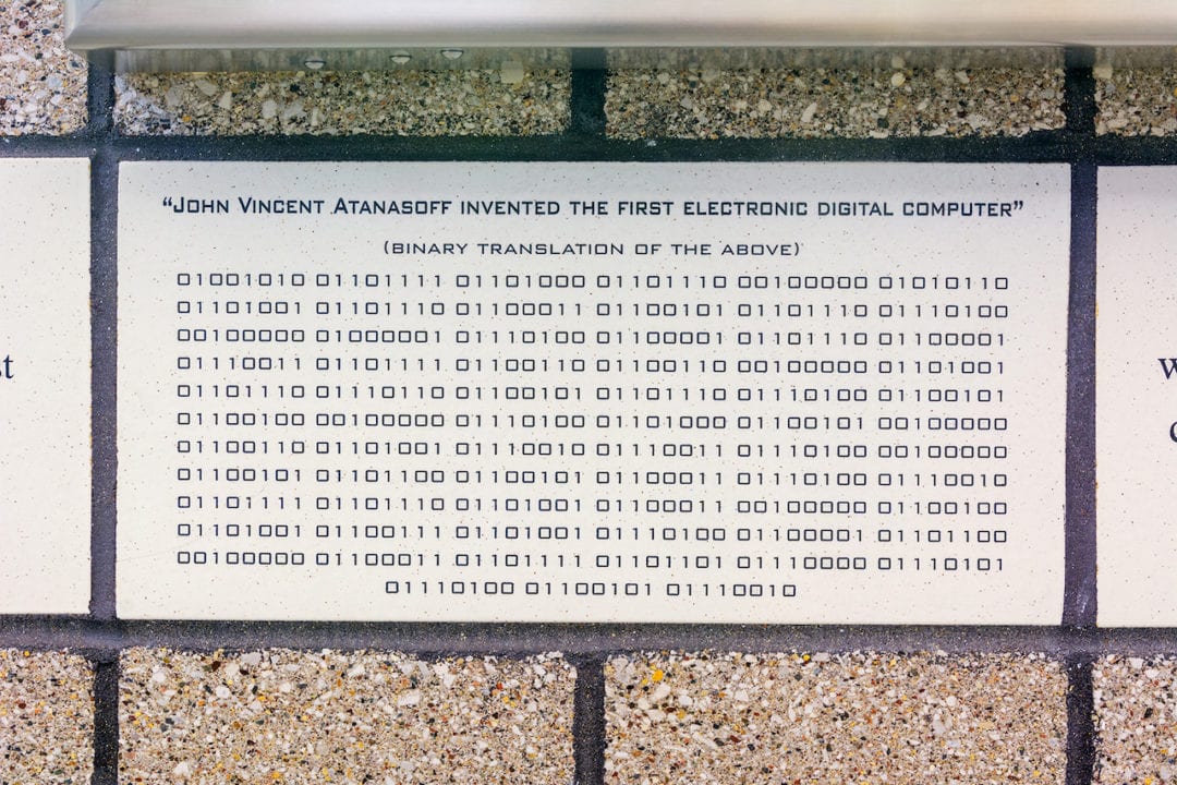 a wall art piece features binary code and reads "John Vincent Atanasoff invented the first electronic digital computer"