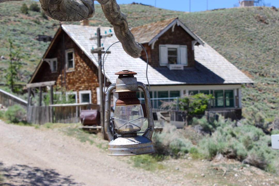 An old miner's lantern hangs from a tree branch outside the clubhouse Cerro Gordo ghost town 