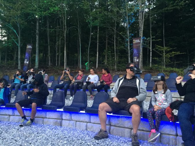 Guests sit at dusk, trying out their headsets