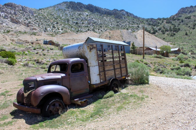 An abandoned horse-hauling truck sits next to the church 