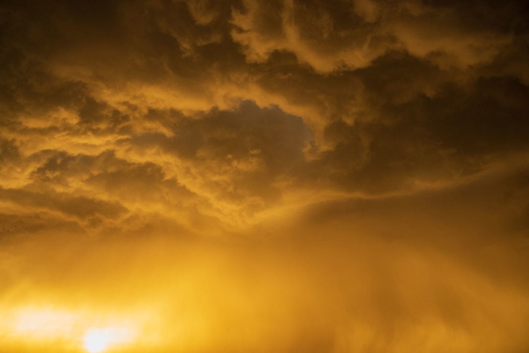 a supercell glows yellow in the sky