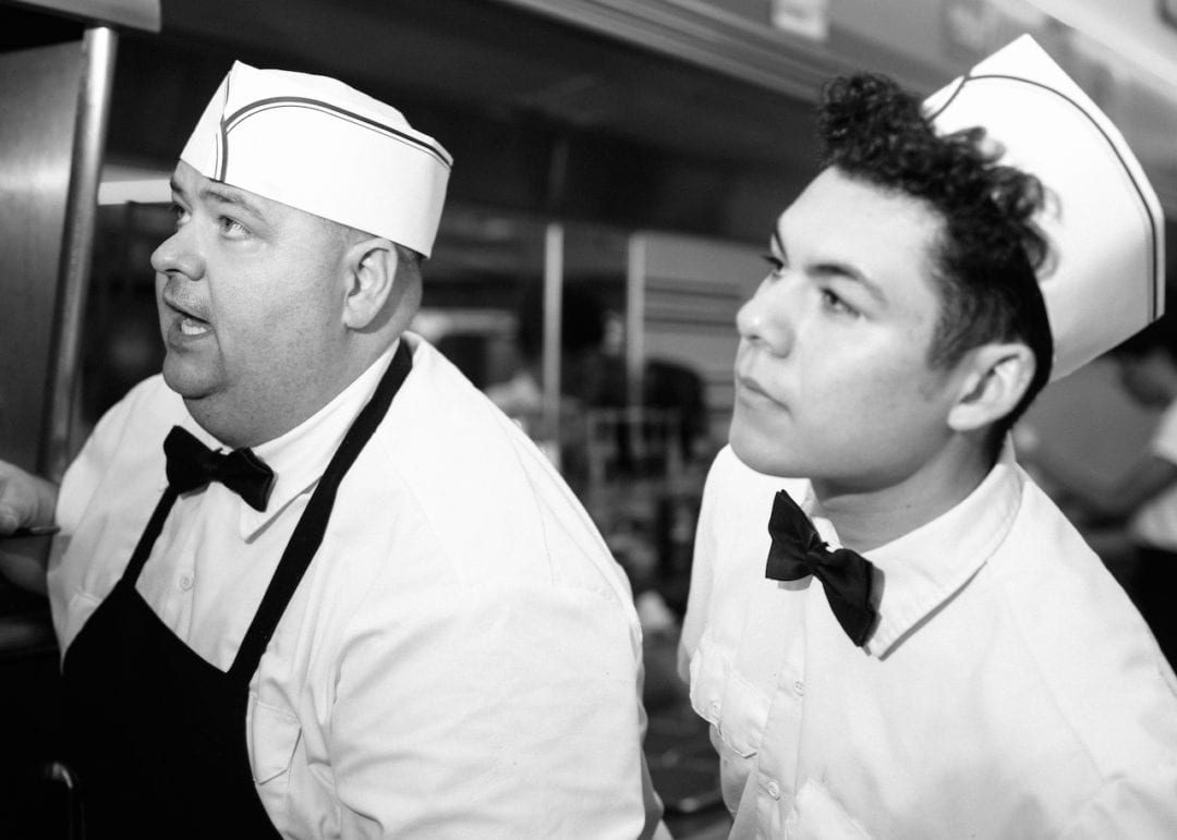 two men look behind the counter of a diner