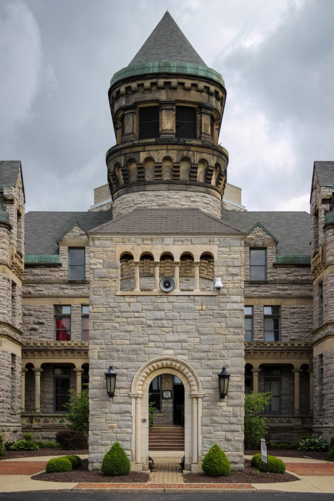 the entrance to an imposing, castle-like beige stone prison