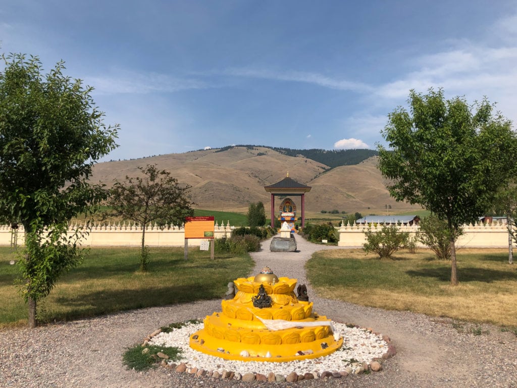 A yellow mandala, which represents an offering to all religions and is marked by idols from Hinduism, Chinese Buddhism, and more.