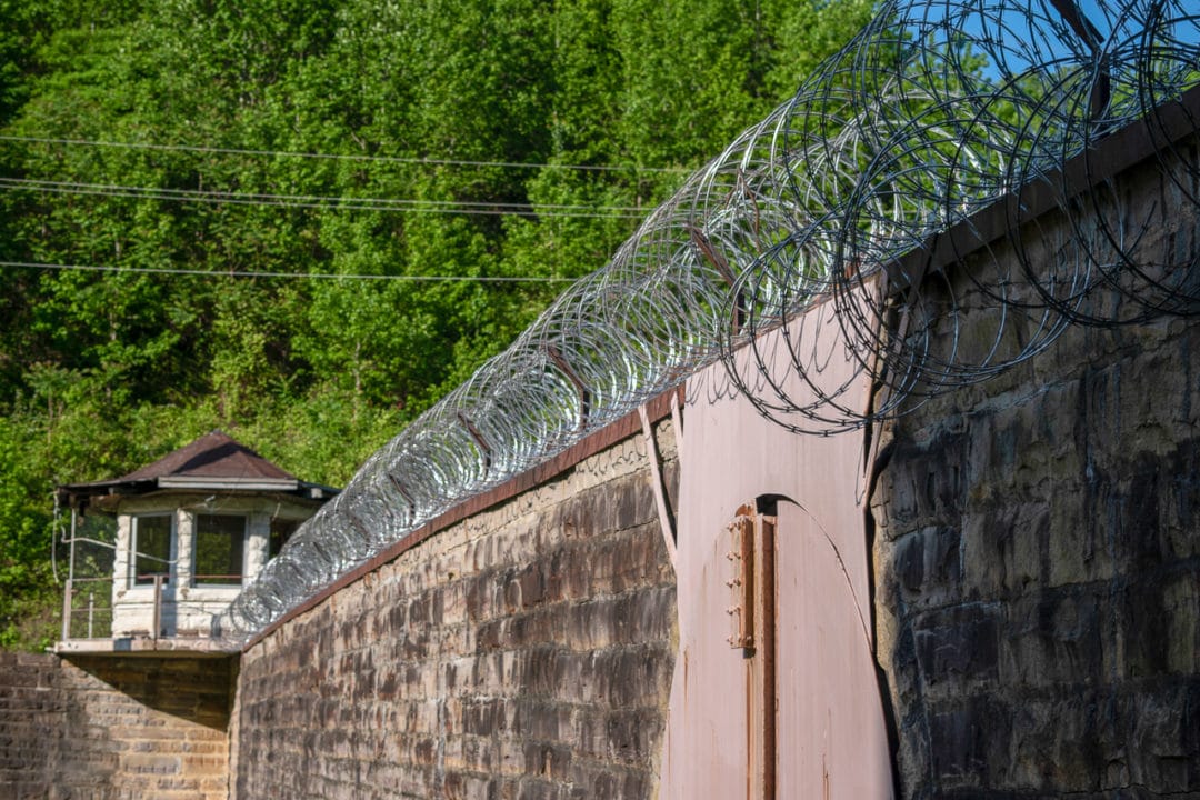 Prison wall lined with barbed wire 