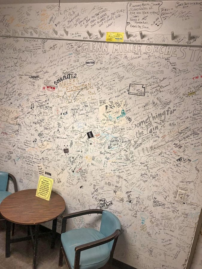 The walls of the dressing room next to the stage are adorned with hundreds of signatures from performers.