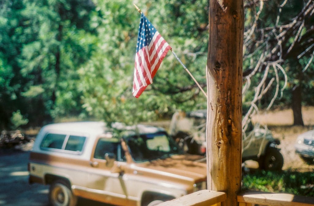 American flag on the porch of the Gin Mill, Shirley's truck in the background