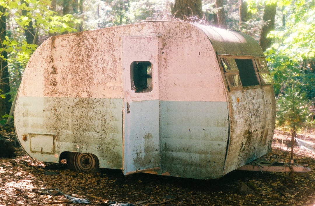 An old camper sits a few steps from the front entrance of the Gin Mill. 