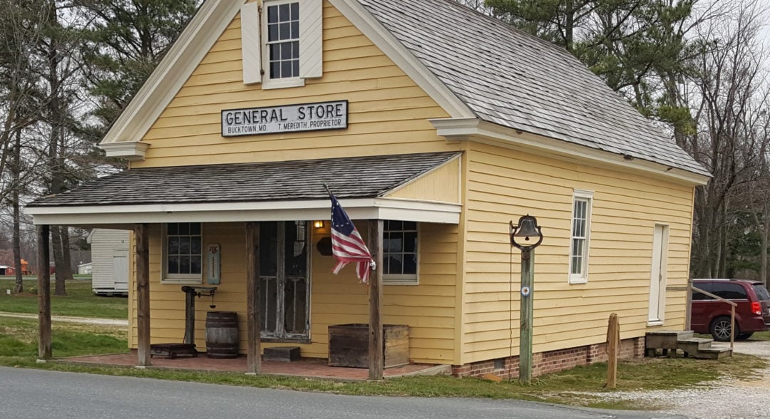 a yellow wooden general store with a porch