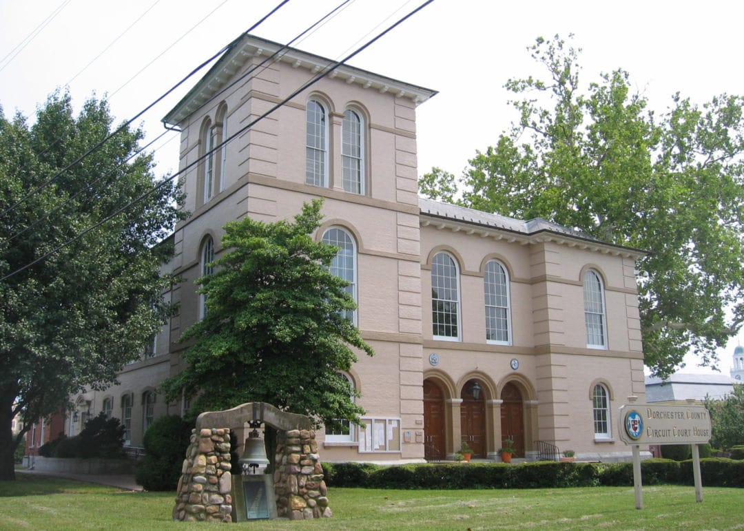 The Dorchester County Courthouse, a pinkish 3-story building with a bell out front