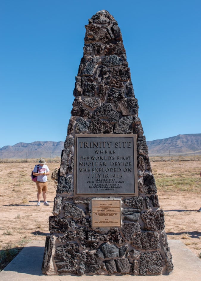 a black lava rock triangular marker with a plaque inscribed: trinity site where the world's first nuclear device was exploded on july 14, 1945