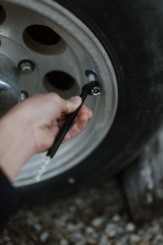 Close up of hand checking tire pressure on RV wheel