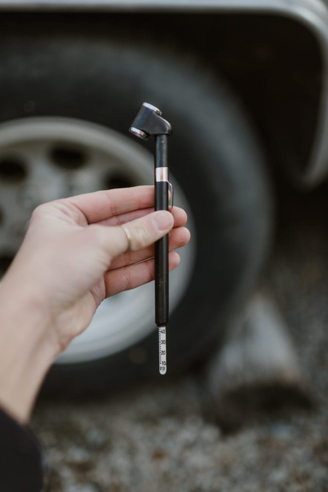 Close up of hand holding a tire pressure gauge