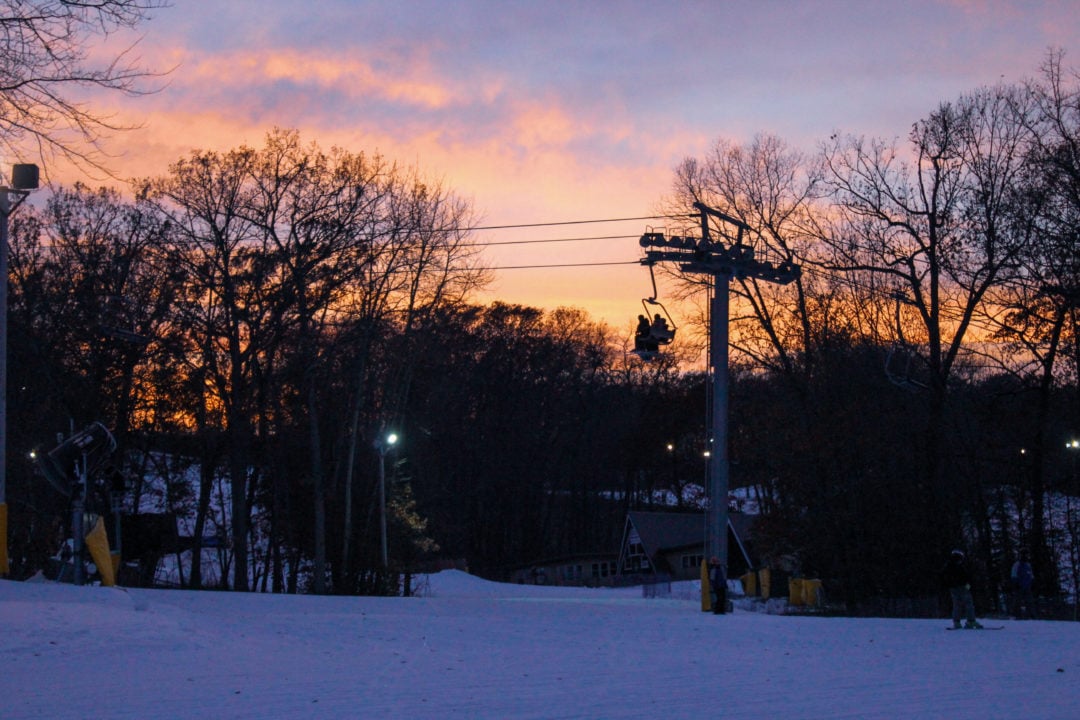 Cascade Mountain ski lift, chair with skiers and a sunset