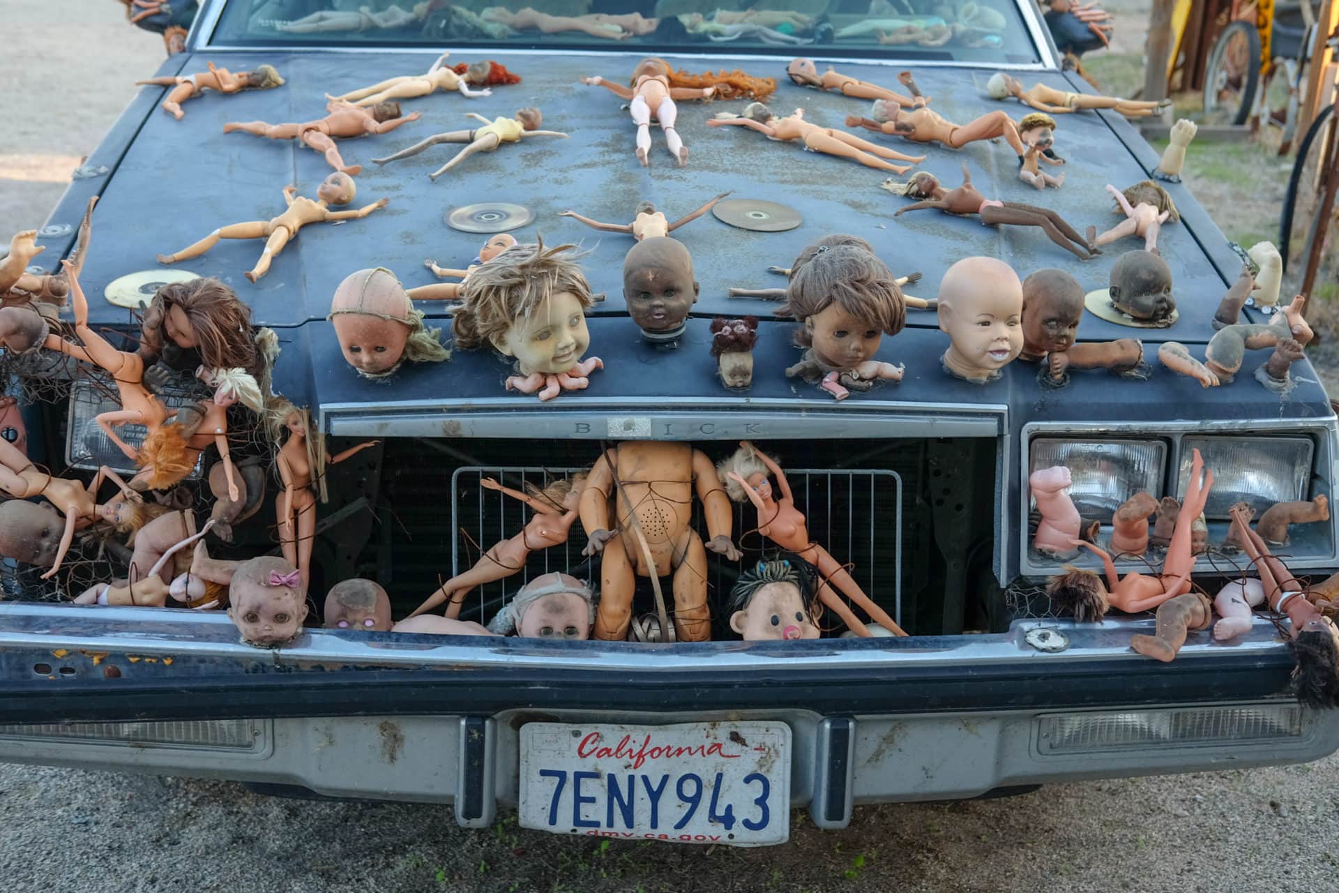A car covered with baby dolls heads is one quirky art piece in East Jesus's outdoor "museum."