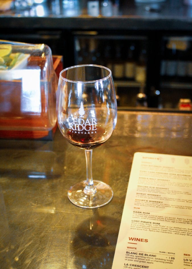 Glass of red wine sitting on bar at Cedar Ridge Winery