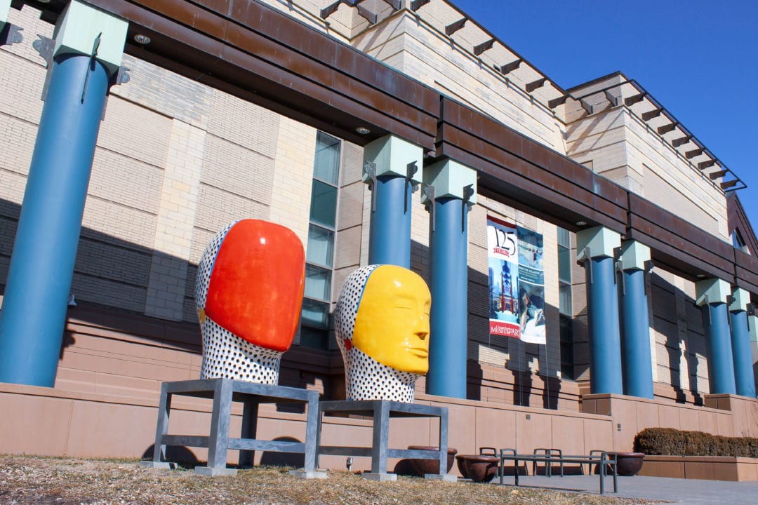 Outside the Cedar Rapids Museum of Art featuring blue pillars and red and yellow head sculptures