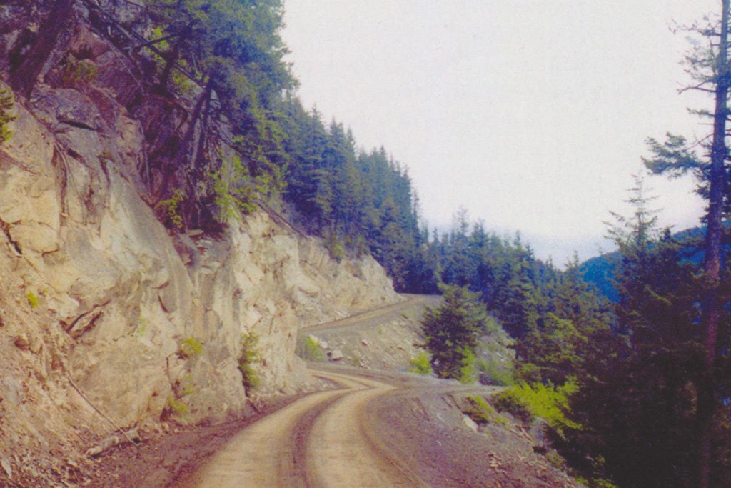 The unpaved stretch of road has no guardrails.