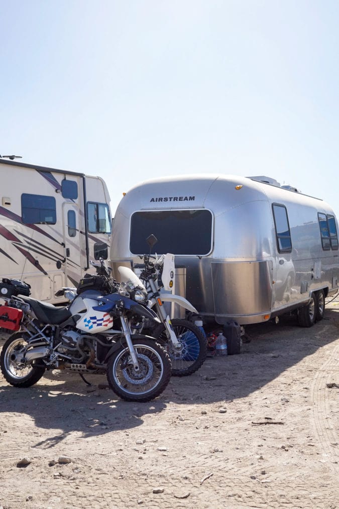 An Airstream and a couple of dirt bikes.