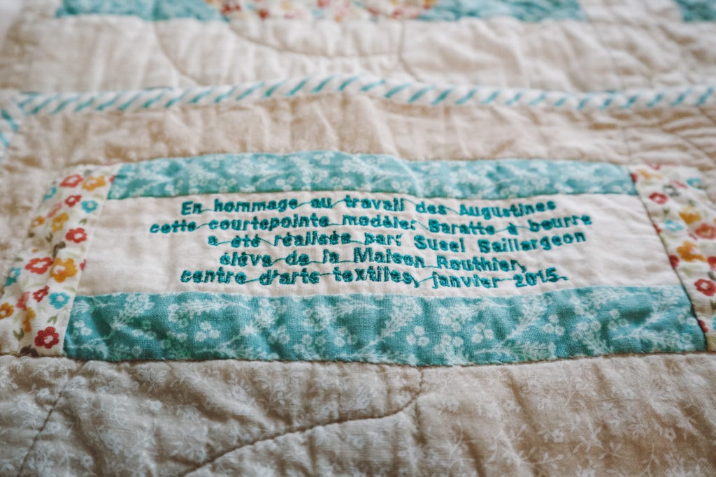 The beds are covered in quilts hand-stitched by Quebec residents