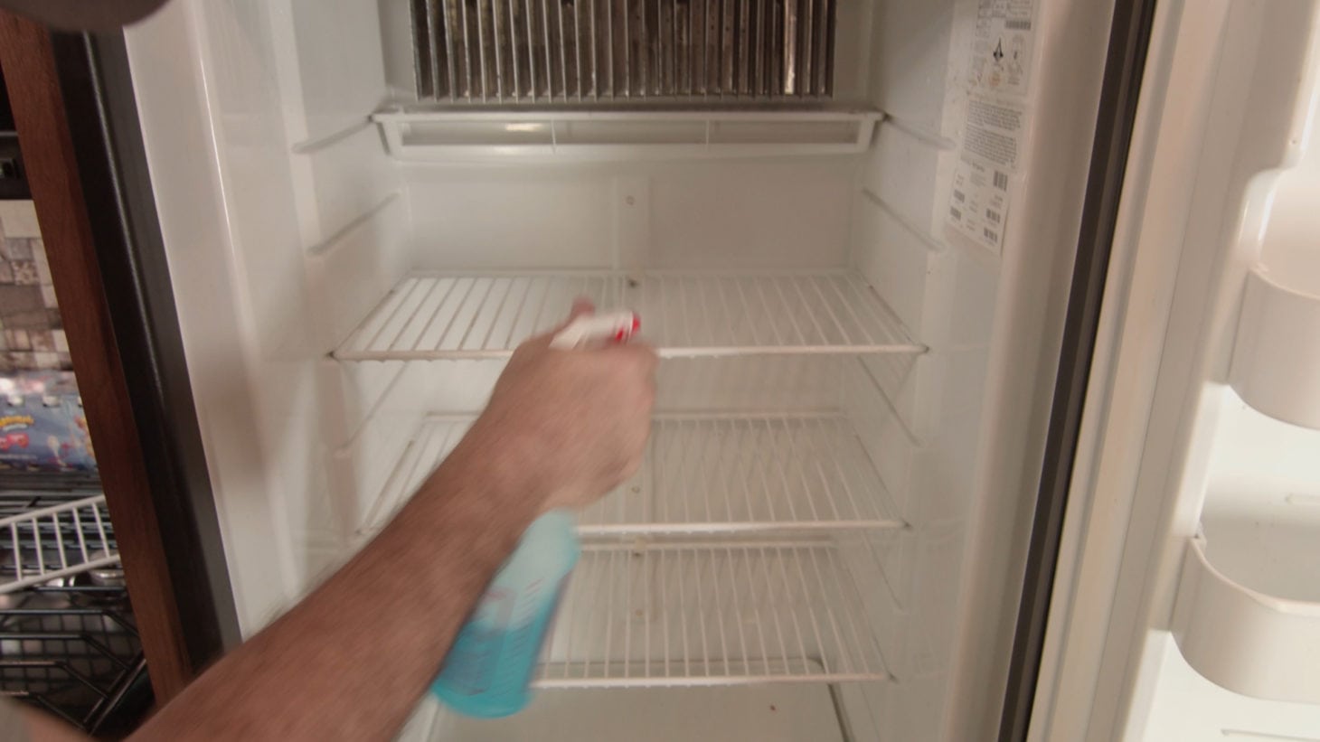 Spraying cleaning product in an RV fridge for cleaning