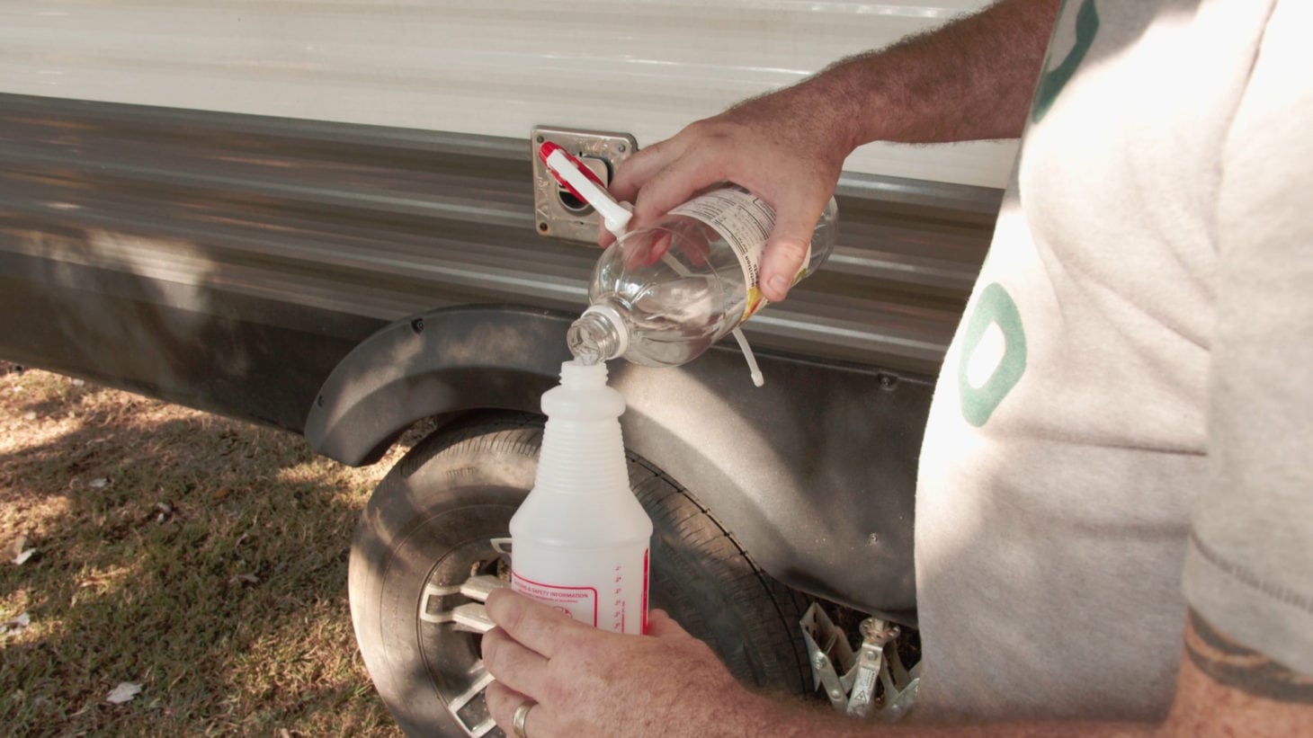 Man creating a water and vinegar mixture to clean exterior of an RV