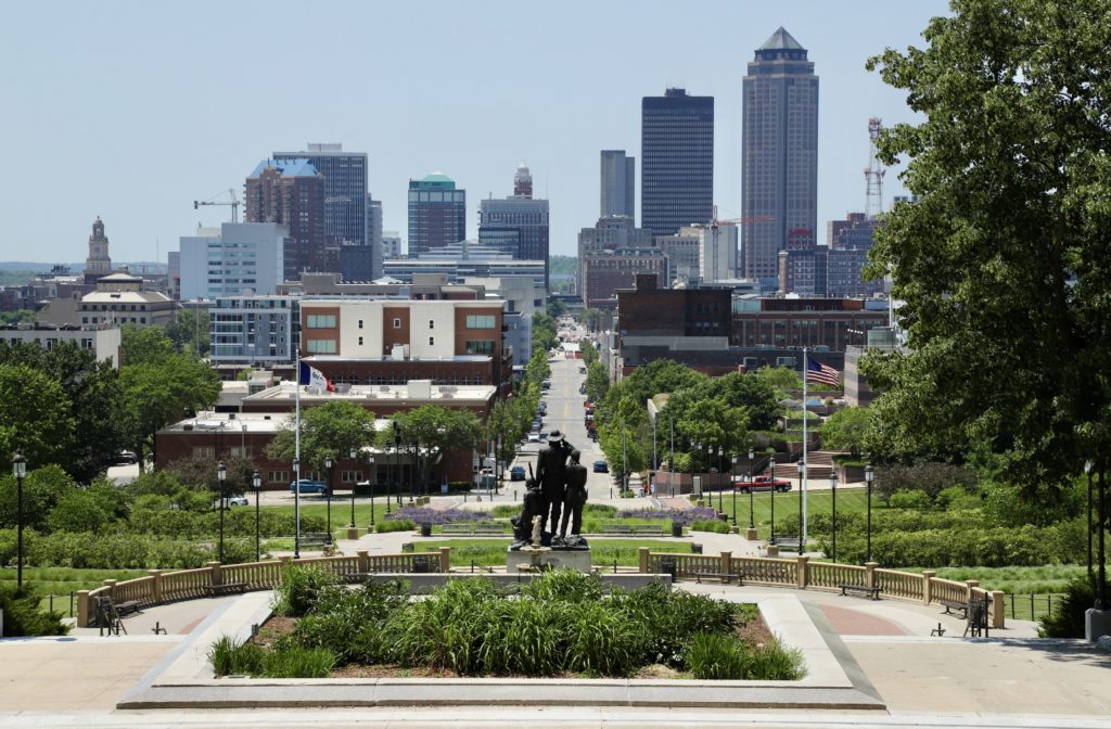 Downtown Des Moines skyline lined with trees and green grass
