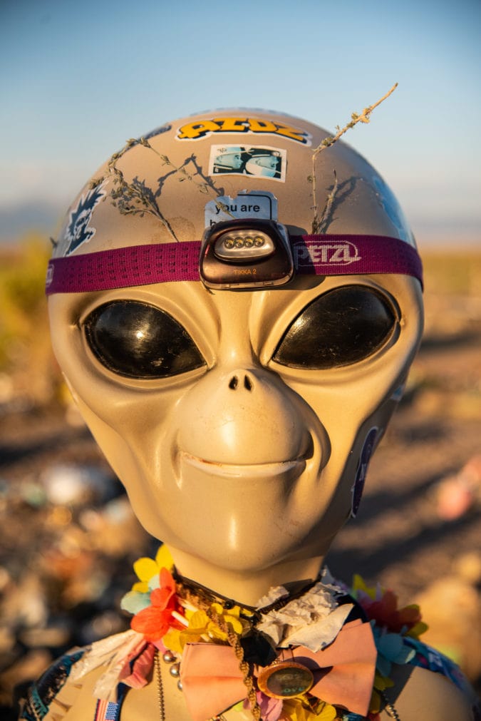 One of the alien figures welcoming visitors to the UFO Watchtower, wearing a headlamp and other decorations. 