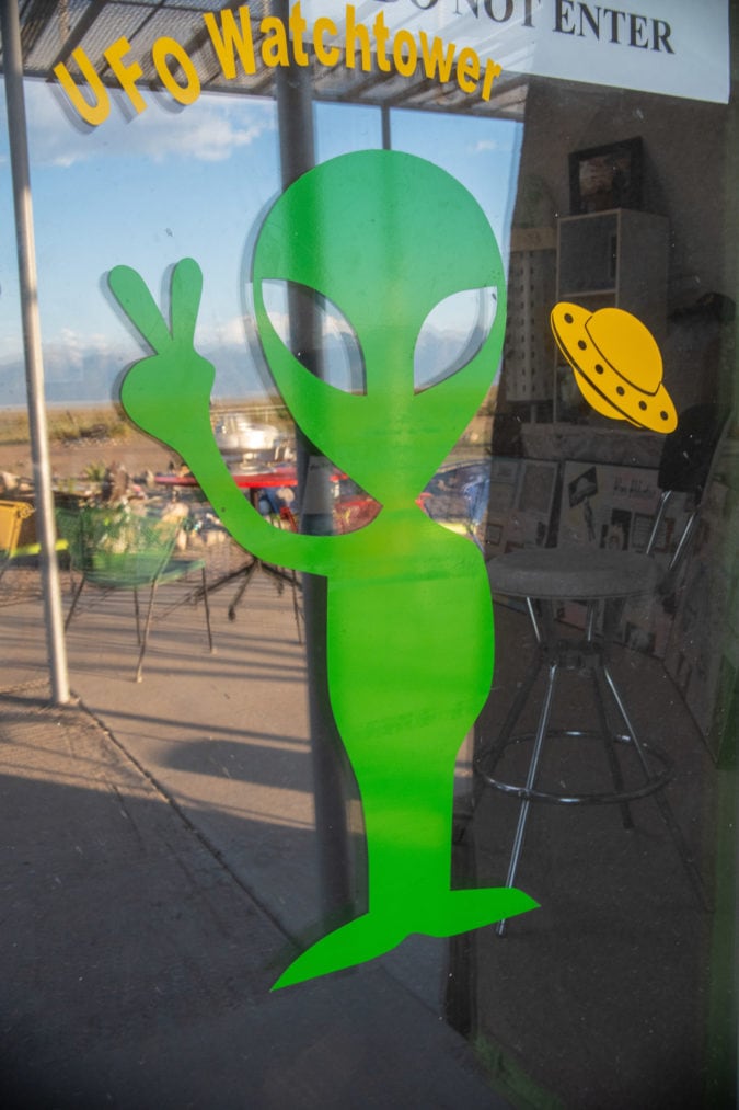 A green alien decal on a gift shop window
