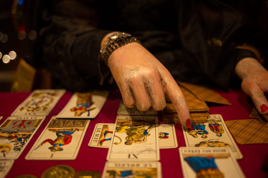 A fortune teller points to cards.