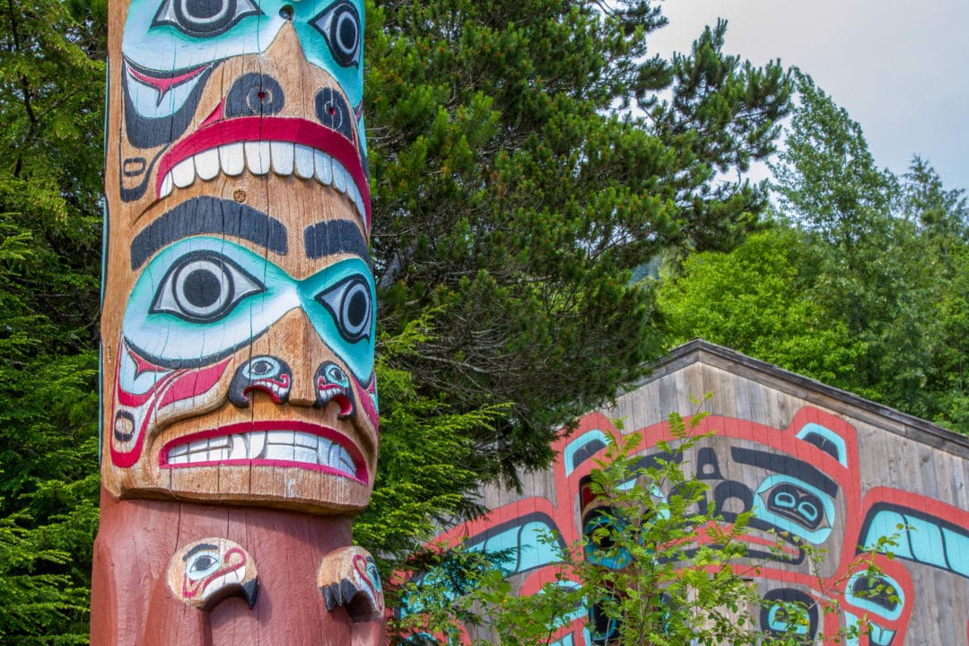 A closeup of a carved and painted face on a totem pole