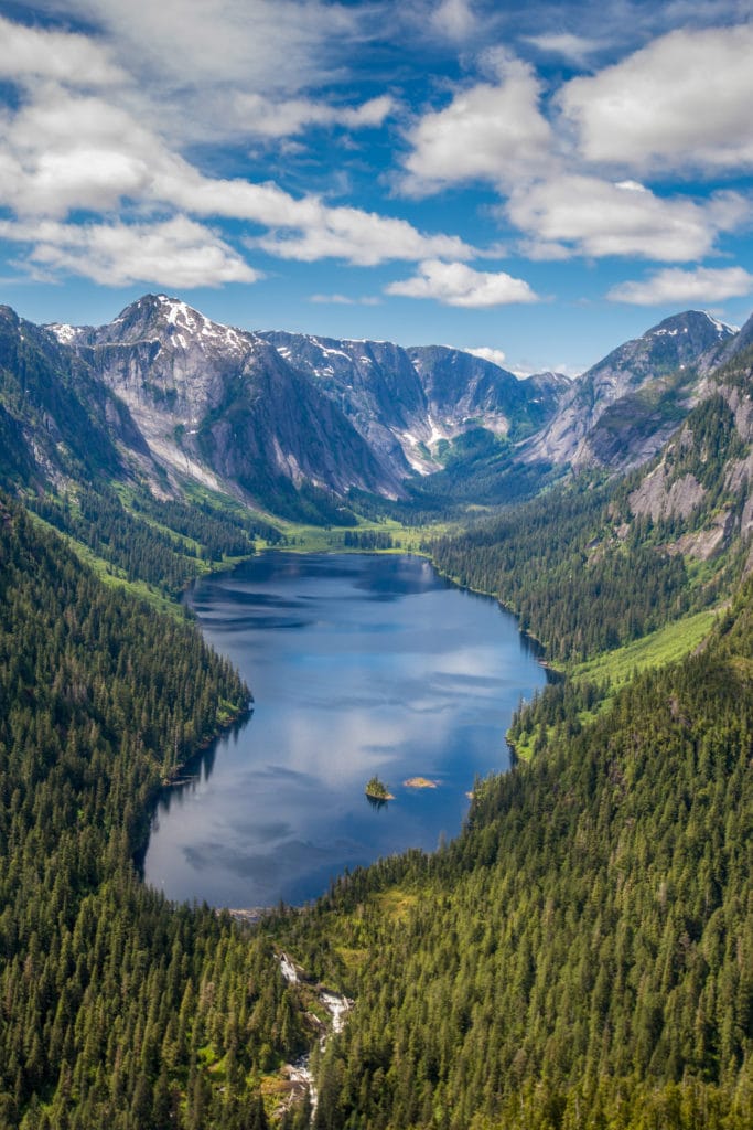 An aerial photo of Misty Fjords National Monument, with a lake surrounded by mountains and trees
