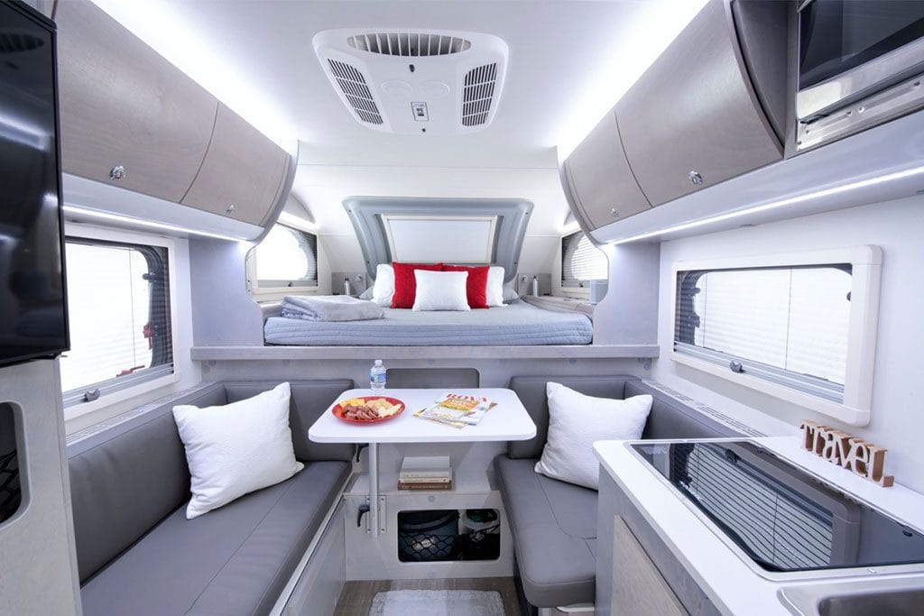 Interior view of truck camper with platform bed and seating area.