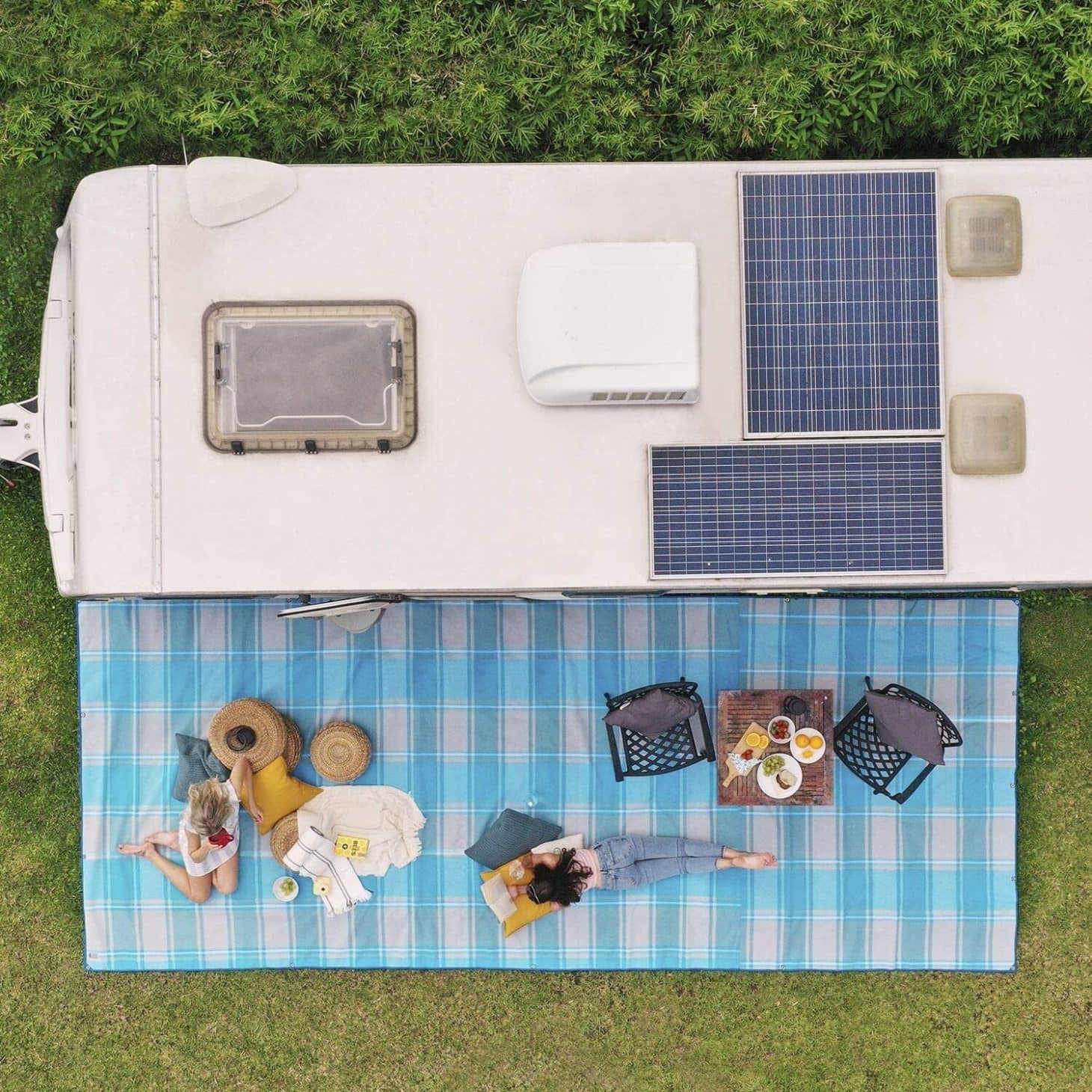Aerial view of campers outside a trailer lounging on RV mat