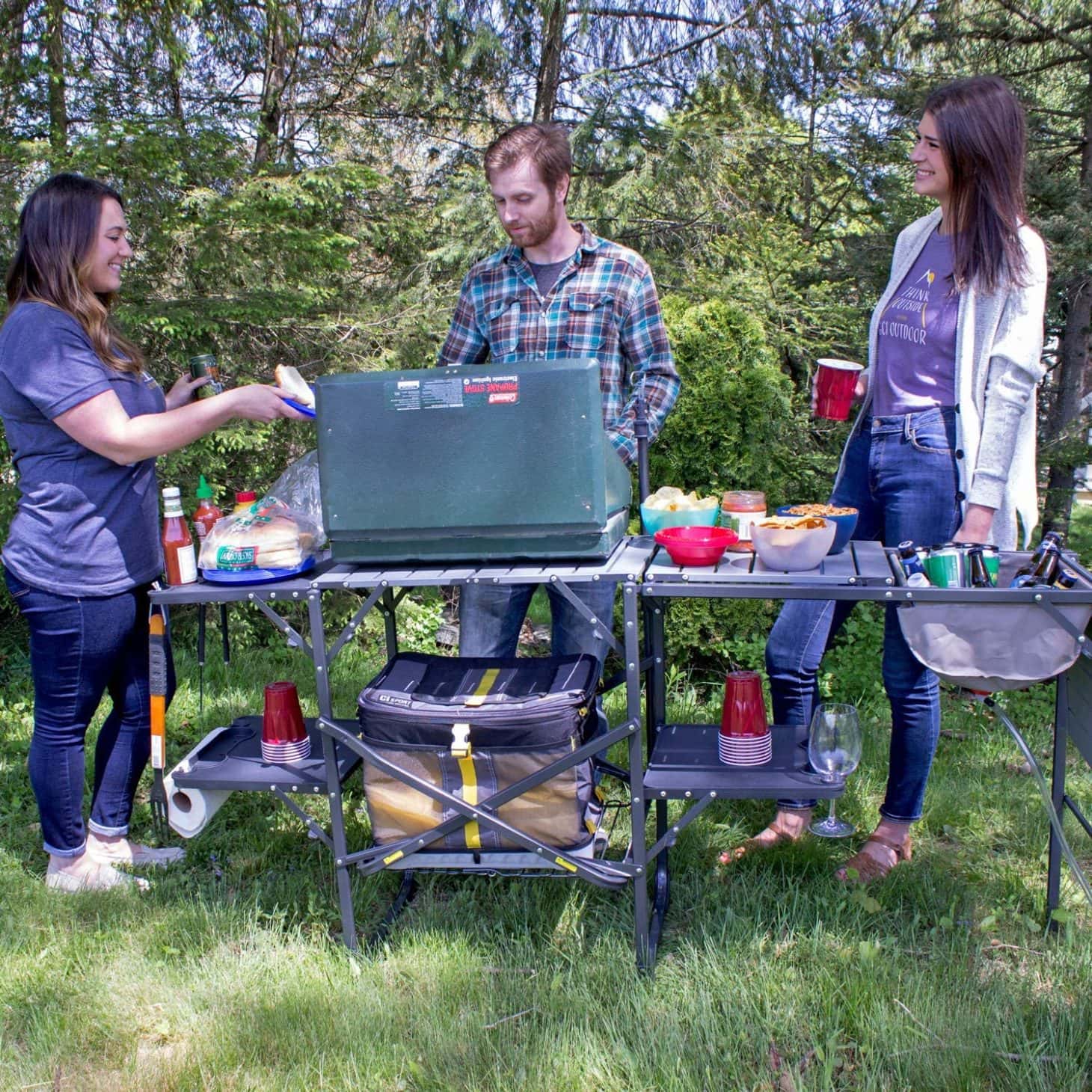 Group of people standing around a packable kitchen